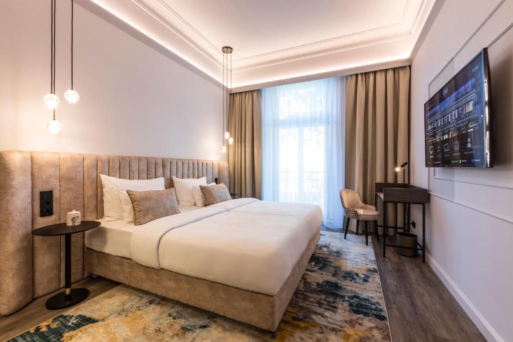 a hotel room with a large bed and a tv at O11 Boutique Hotel Vienna in Vienna