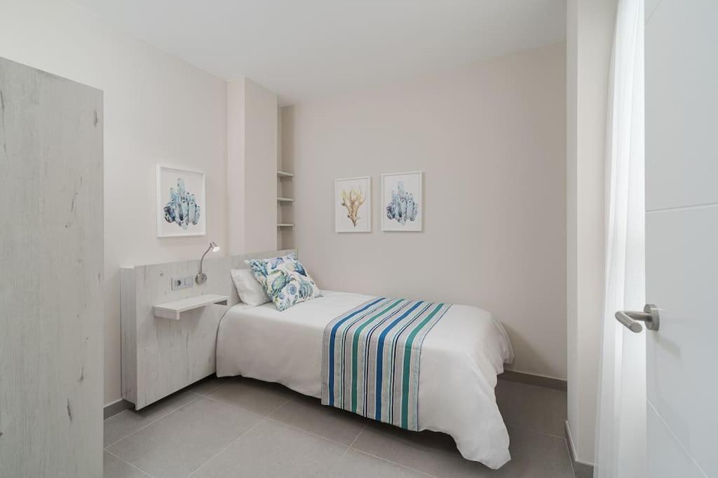 a white bedroom with a bed and a sink at Las Afortunadas , Playa Arinaga 1ºA in Arinaga
