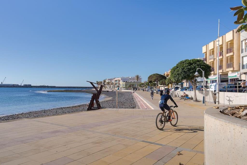 a person riding a bike on a beach at Las Afortunadas , Playa Arinaga 1ºA in Arinaga