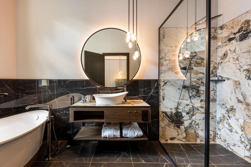 a bathroom with a tub and a sink and a mirror at O11 Boutique Hotel Vienna in Vienna