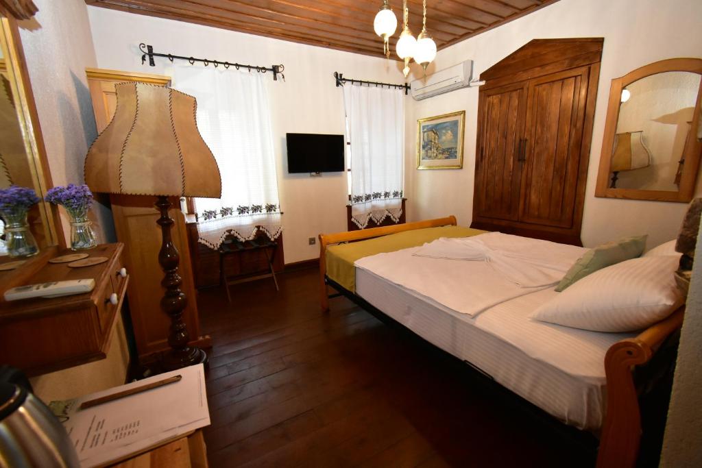 ein Schlafzimmer mit einem Bett, einer Lampe und einem Spiegel in der Unterkunft Olivia1845 Guest House Ayvalık in Ayvalık