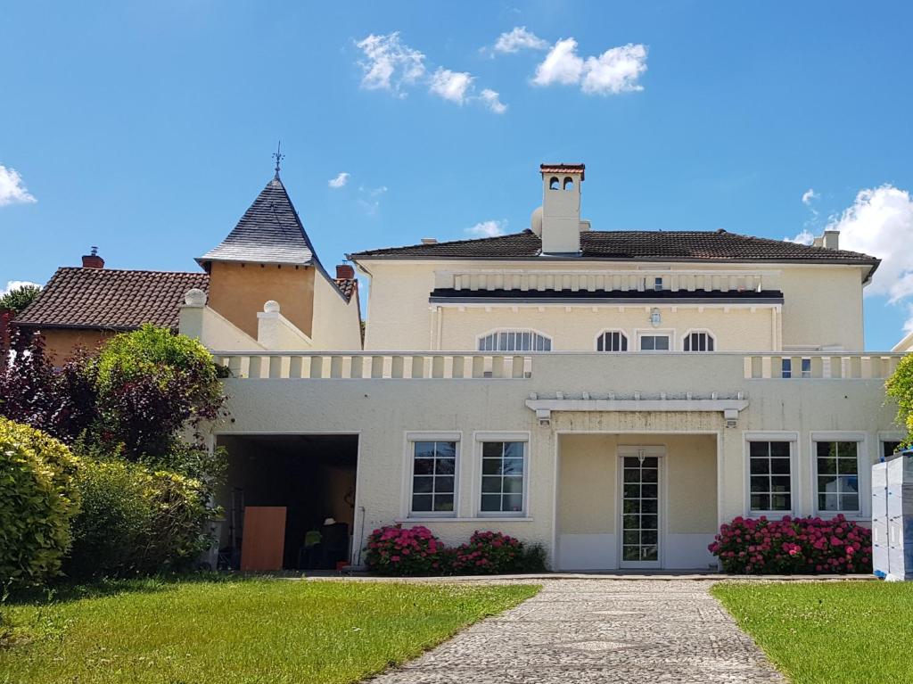 a large white house with a driveway at La Casa Blanca in Janneyrias