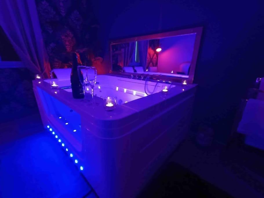 baño con bañera con espejo y luces en Suite privée avec BALNEO (Jacuzzi ou baignoire). en Yvetot
