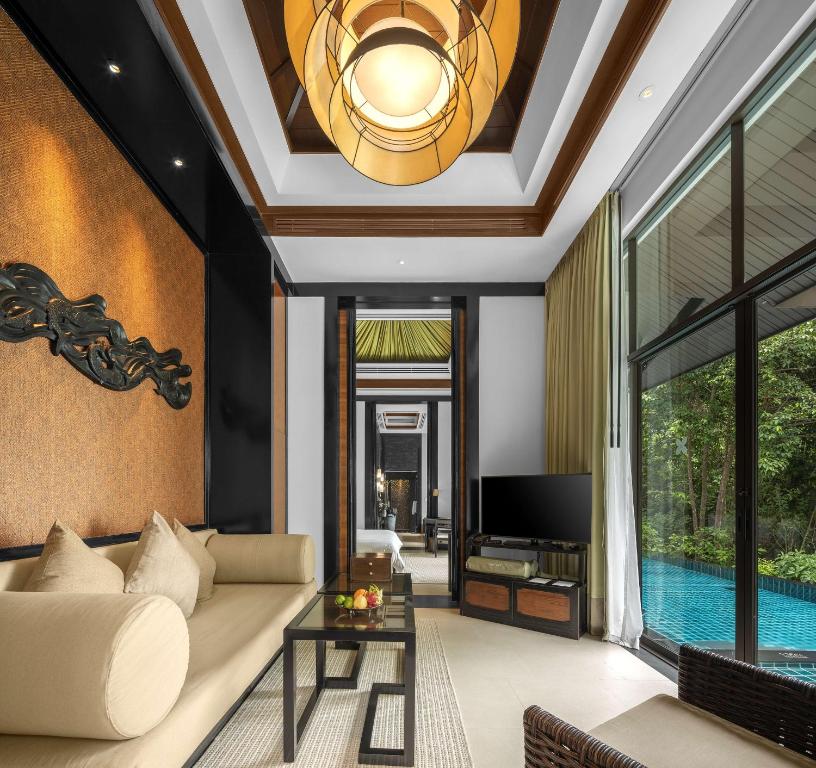 a living room with a couch and a tv at Banyan Tree Samui - SHA Extra Plus in Lamai