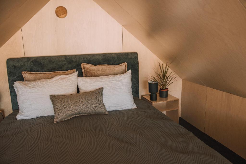 a bedroom with a large bed with white pillows at PullanHouse Līksma - small and cosy lakeside holiday house in Alūksne