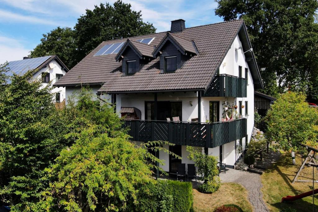 a white house with a black roof at Ferienwohnung Sonnenhang-Hartmann in Olsberg