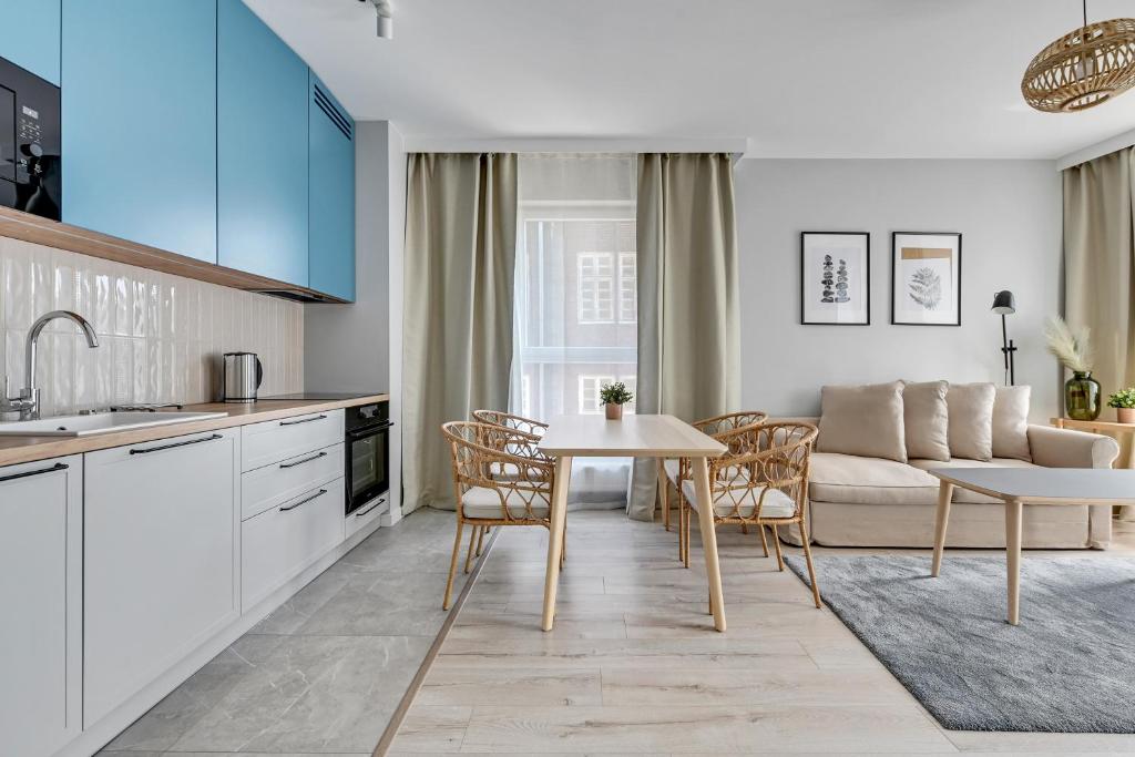 a kitchen and living room with a table and a couch at Flatbook - City Center Apartments Bastion Wałowa in Gdańsk