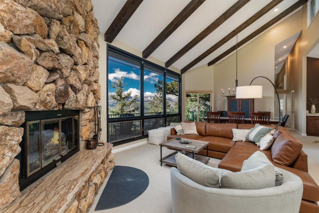 a living room with a large stone fireplace at Cedar Upper Condominium 3 Bedroom condo in Estes Park
