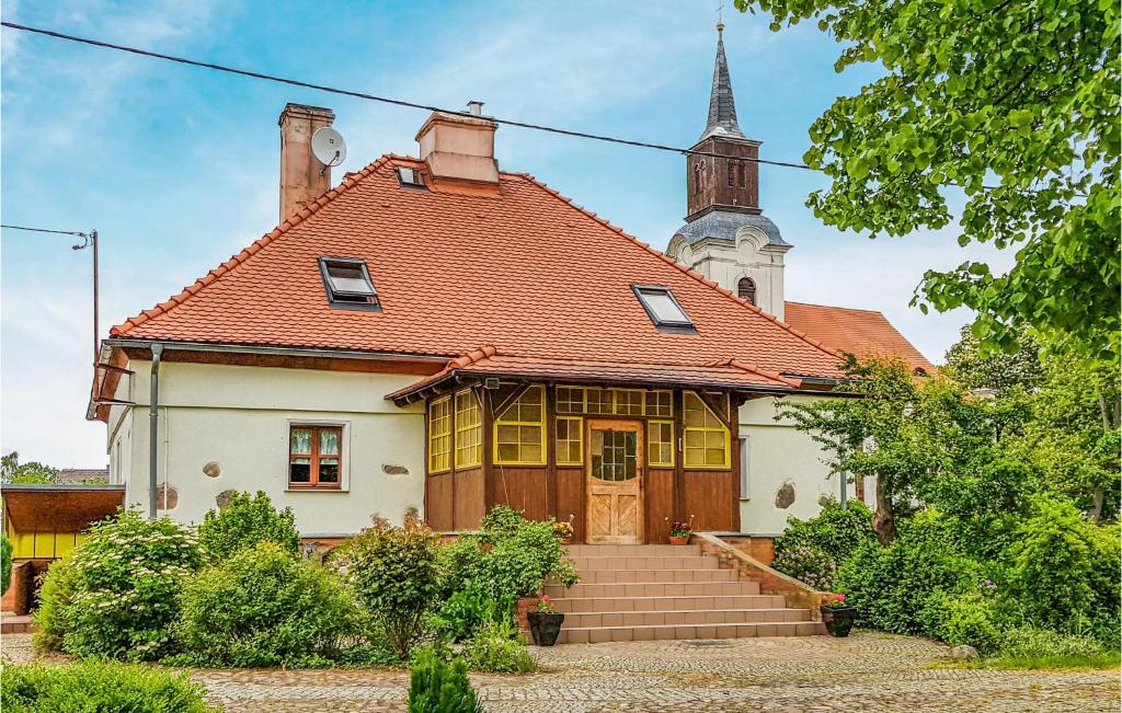una vecchia casa con una chiesa sullo sfondo di Amazing Home In Skape With Kitchen a Skąpe