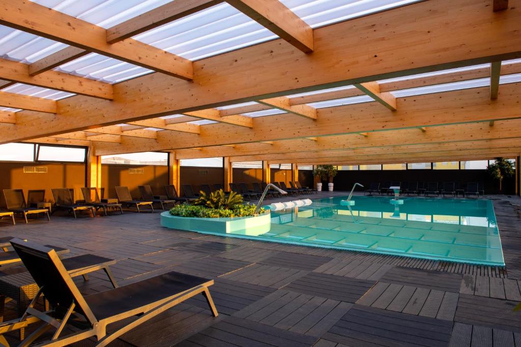 uma piscina interior com um telhado com clarabóias em Hotel Cristal Vieira Praia & SPA em Praia da Vieira