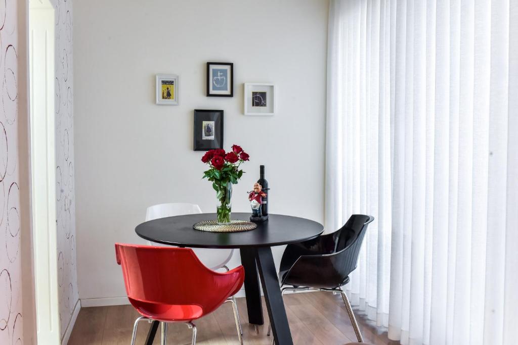 a dining room with a black table and red chairs at SOKOLOV Vacation Boutique Apartments by the sea in nahariya in Nahariyya