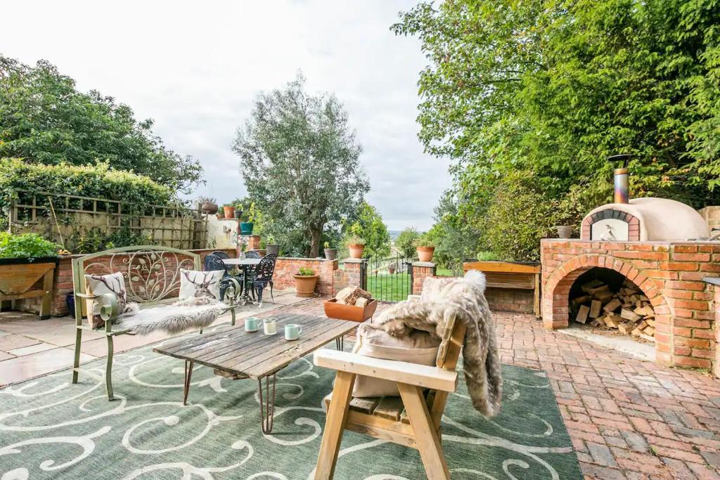 a patio with a table and a brick fireplace at Idyllic 2- Bedroom barn with amazing views in Cranbrook