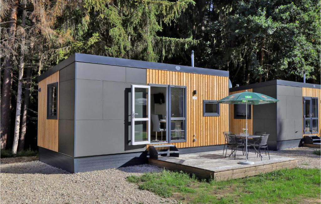 a tiny house with a table and an umbrella at Tiny Haus 14 Am Brombachsee in Pleinfeld