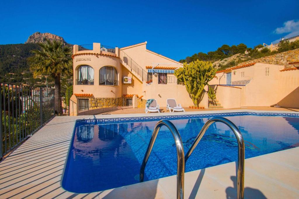 a swimming pool in front of a house at Villa Markus - Plusholidays in Calpe