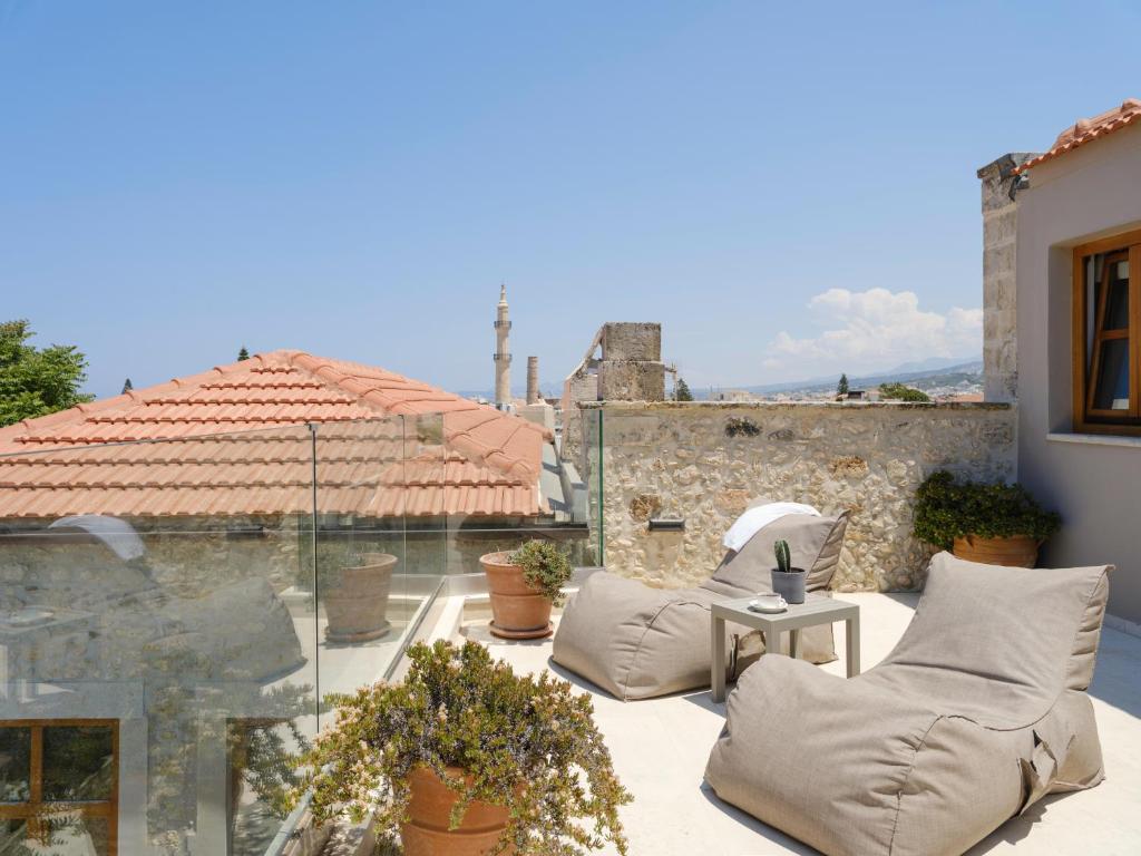 eine Terrasse mit 2 Stühlen und einem Tisch auf einem Gebäude in der Unterkunft Casa Dei Delfini in Rethymno