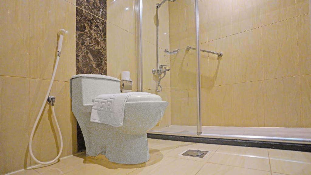 a bathroom with a toilet and a shower at EKONO by Leva Jeddah Airport Hotel in Jeddah