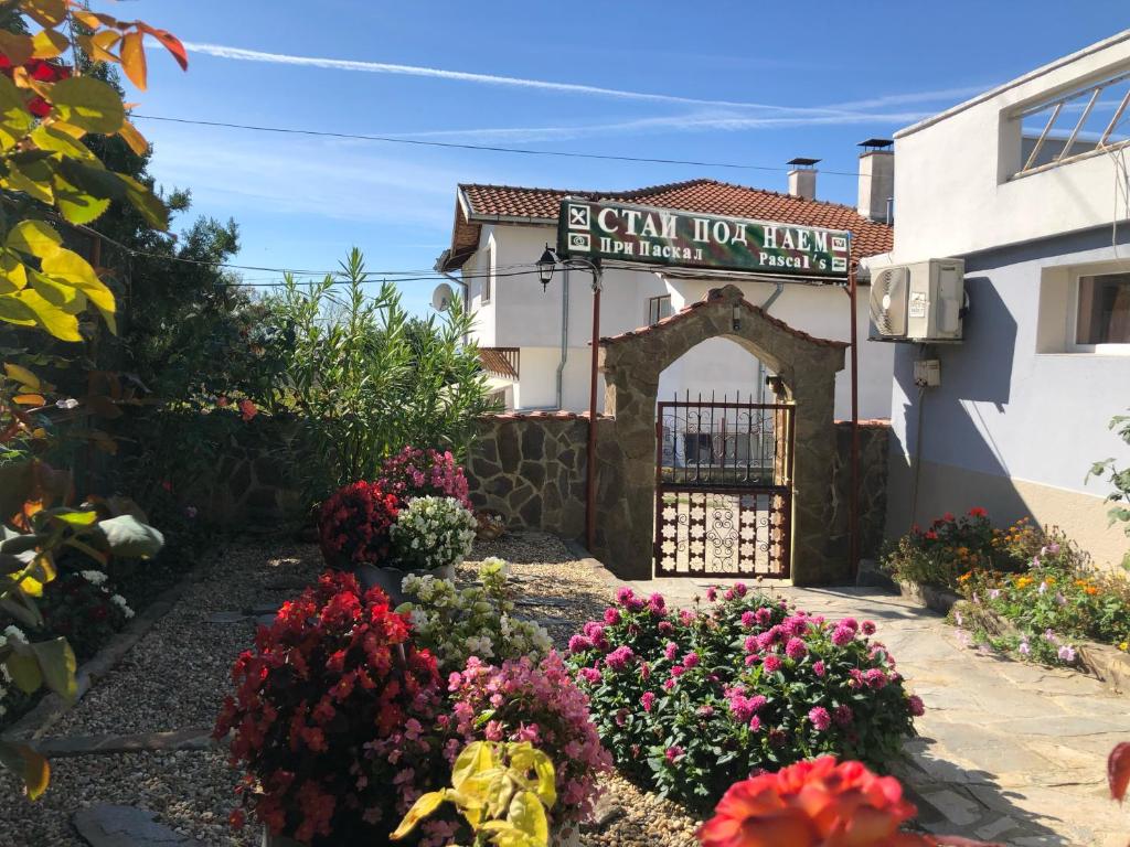 a sign for a hotel with flowers in front of it at Guest House Paskal in Balchik