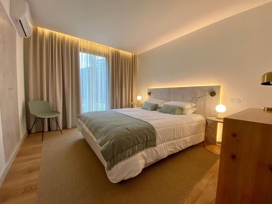 1 dormitorio con cama grande y ventana grande en Nature & Sea - Casa da Vinhateira South, en Caloura