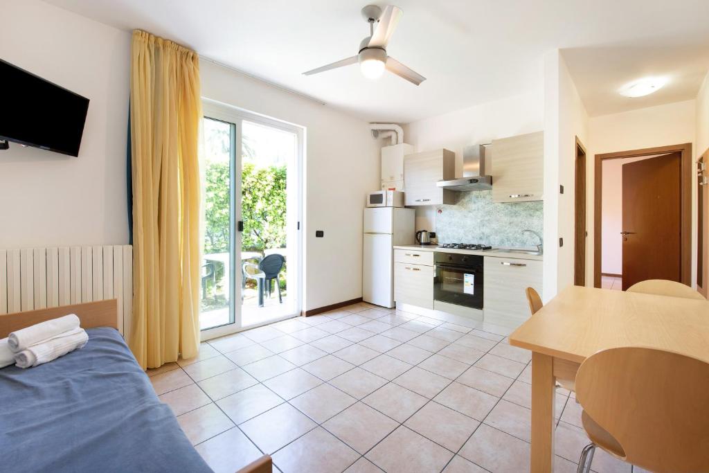 a kitchen and a living room with a bed and a table at Garda resort appartamento 4 in Toscolano Maderno