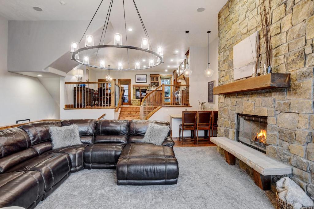 a living room with a leather couch and a fireplace at Ski In Out Luxury Villa #492 With Hot Tub & Great Views - 500 Dollars Of FREE Activities & Equipment Rentals Daily in Winter Park