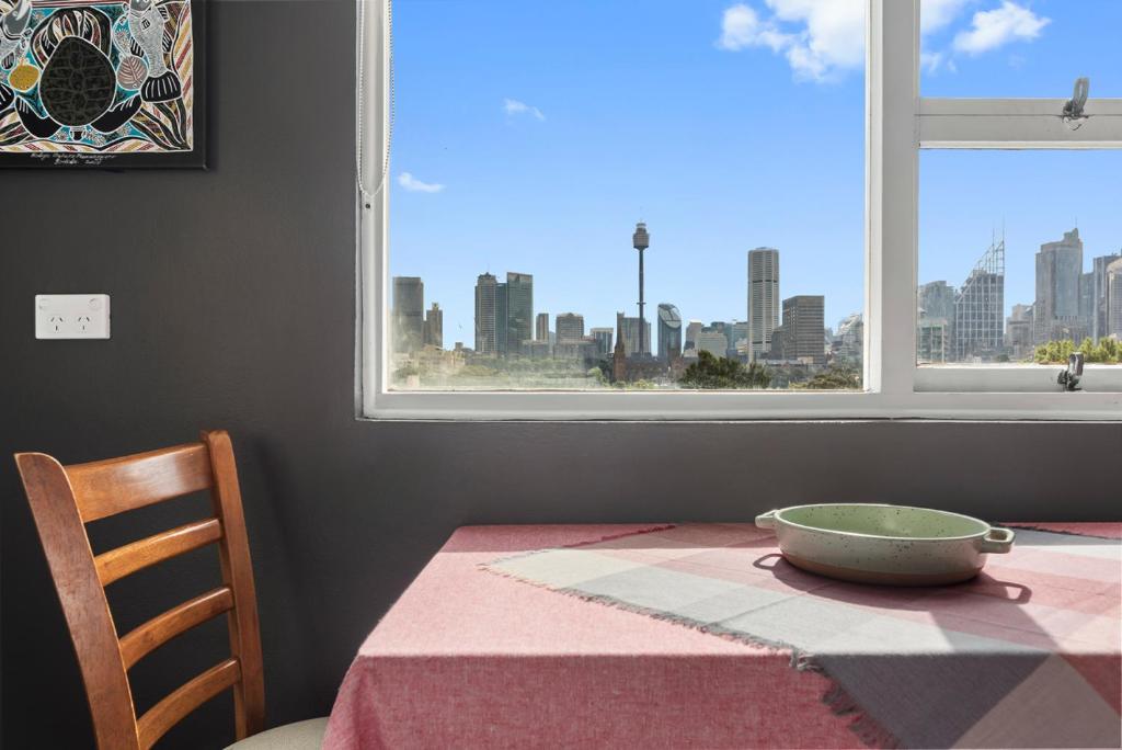 a table with a bowl on a table with a window at BROUG10W - City View Studio in Sydney