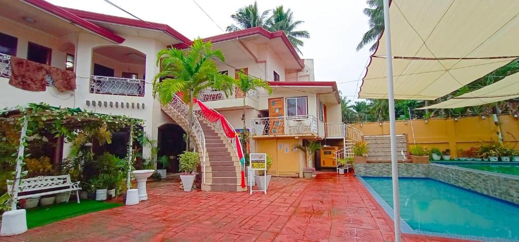 a house with a swimming pool next to a building at Ladolcevita Inland Resort in Cabadbaran