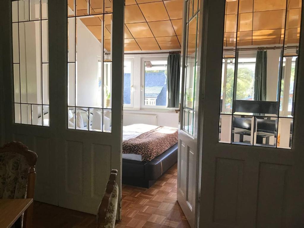 a bedroom with a bed and a door with a window at Ferienwohnung in Villa in Bad Elster