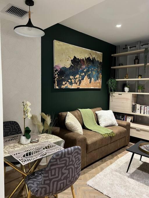 a living room with a couch and a green wall at 715 Foreshore Place Luxury Apartment-Cape Town CBD in Cape Town