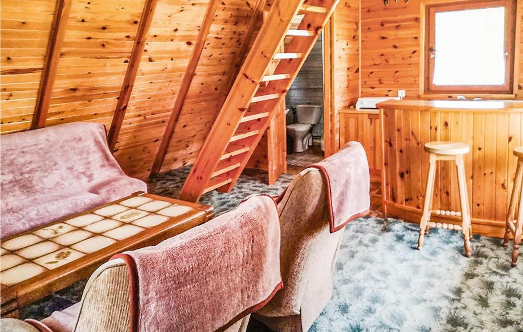 ein Zimmer mit einer Treppe und Stühlen in einer Hütte in der Unterkunft Beautiful Home In Kartuzy With Kitchen in Karthaus