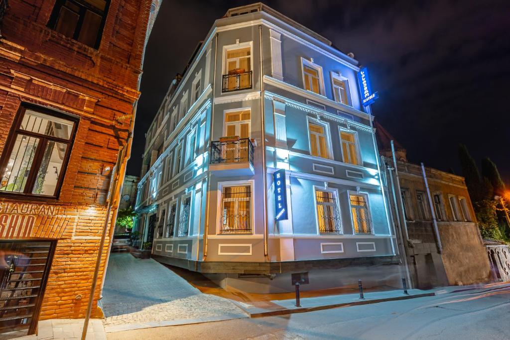 un edificio con luces azules en el lateral. en Sharden Hotel, en Tiflis