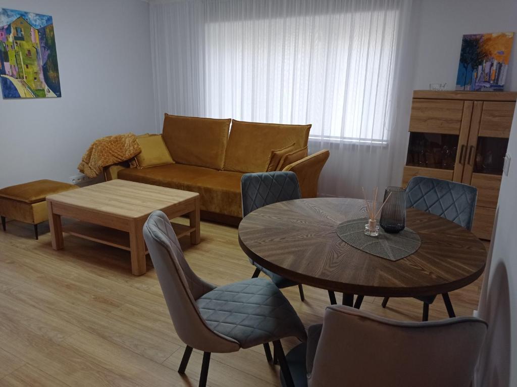 a living room with a table and chairs and a couch at TIMO butas in Druskininkai