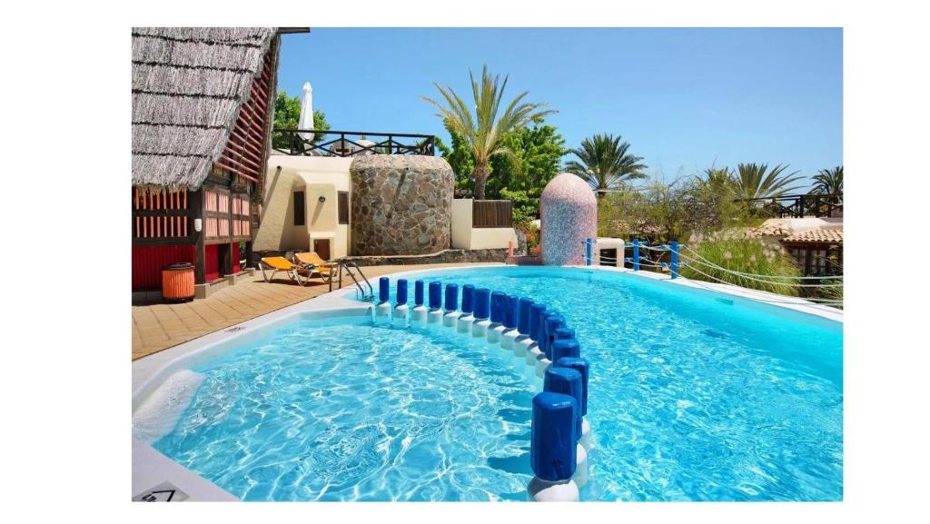 a pool with a water slide in front of a house at VCV VILLA BAHÍA FELIZ in Playa del Aguila