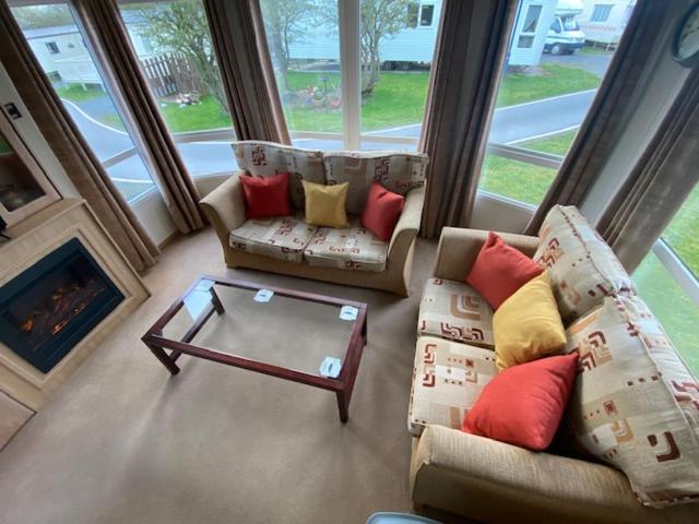 a living room with two chairs and a coffee table at Lili-anns Retreat Cosy Holiday Home in Millom