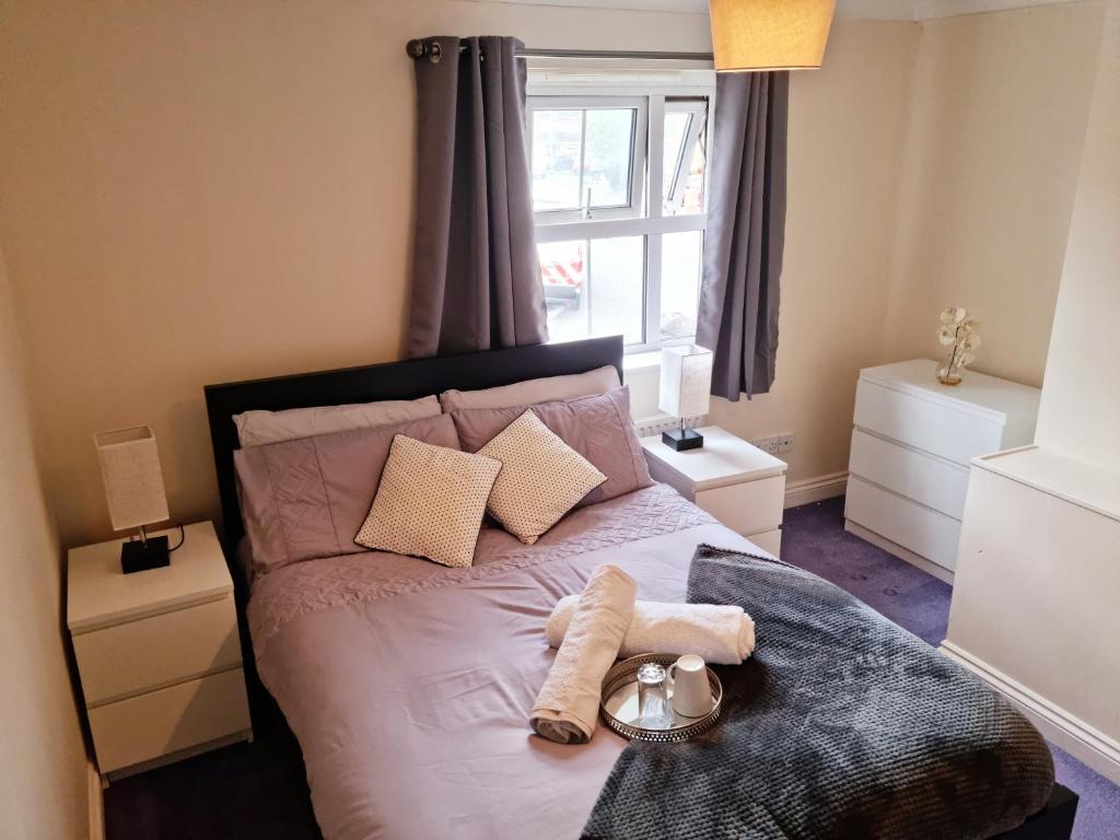 - une chambre avec un lit et une serviette dans l'établissement The TJ Rooms, à Upton