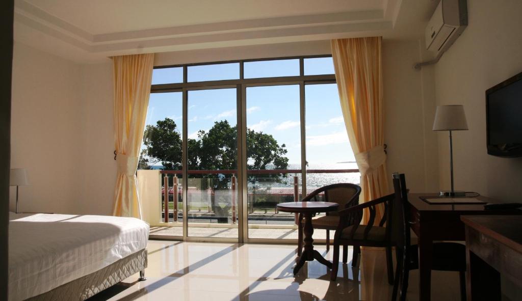 a bedroom with a bed and a large window at Emerald Hotel & Restaurant in Nuku‘alofa