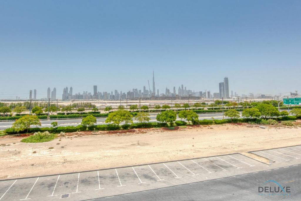 an empty freeway with a city in the background at Contemporary 1BR at Prime Views Meydan by Deluxe Holiday Homes in Dubai