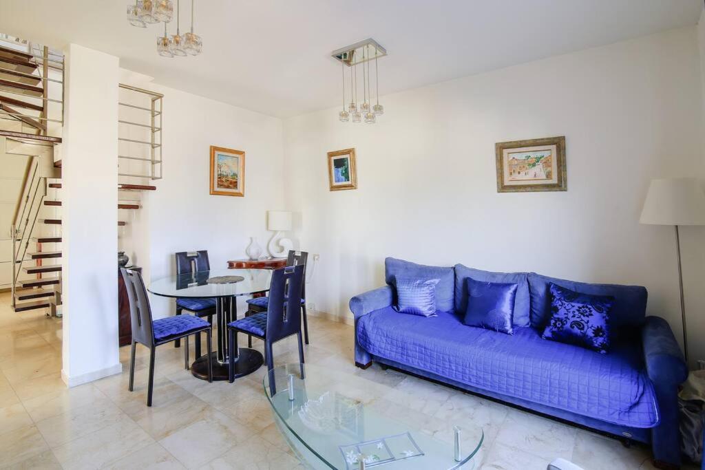 - un salon avec un canapé bleu et une table dans l'établissement Duplex 2BR in Ben Yehuda by Holiday-rentals, à Tel Aviv