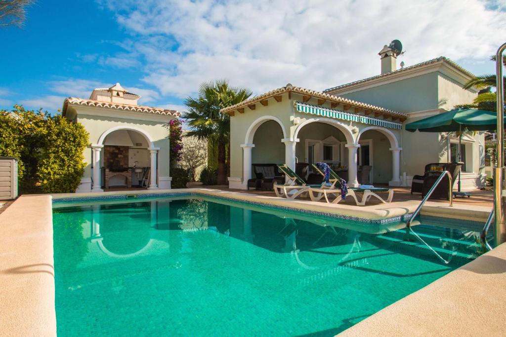a swimming pool in front of a house at Villa Yoko - Plusholidays in Calpe