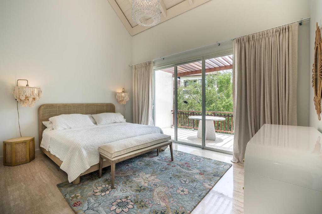 a white bedroom with a bed and a balcony at Newly Added El Portillo 2BR Apt in Abra Grande
