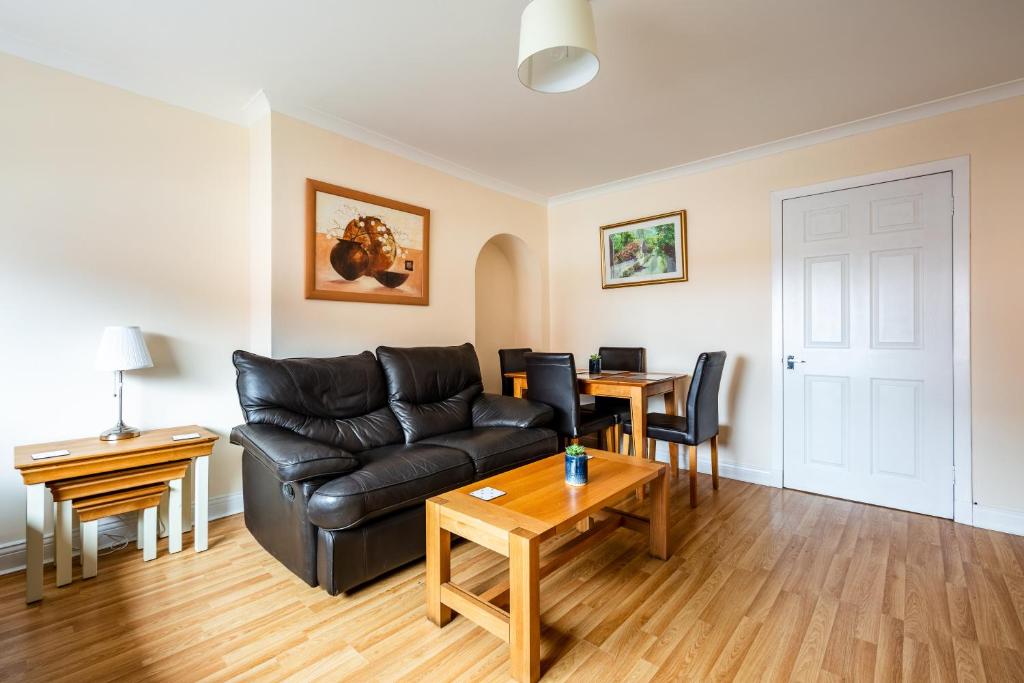 a living room with a couch and a table at Scotia House -3 bed house in Larkhall with private driveway in Larkhall