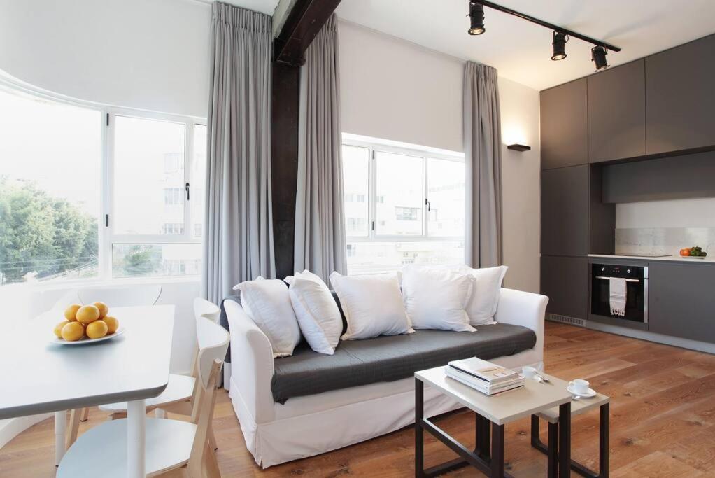 uma sala de estar com um sofá branco e uma mesa em Modern 1BR in Dizengoff by Holiday-rentals em Tel Aviv