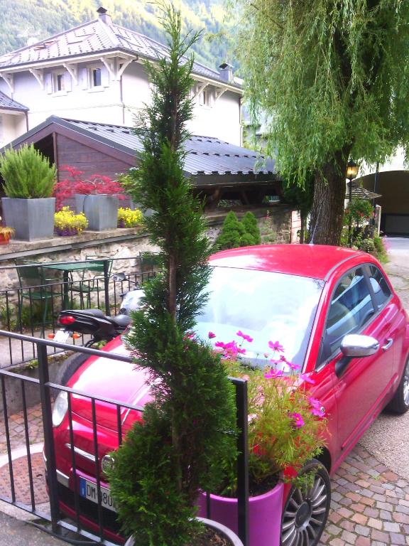 a red car parked next to a christmas tree at Hotel Du Clocher in Chamonix