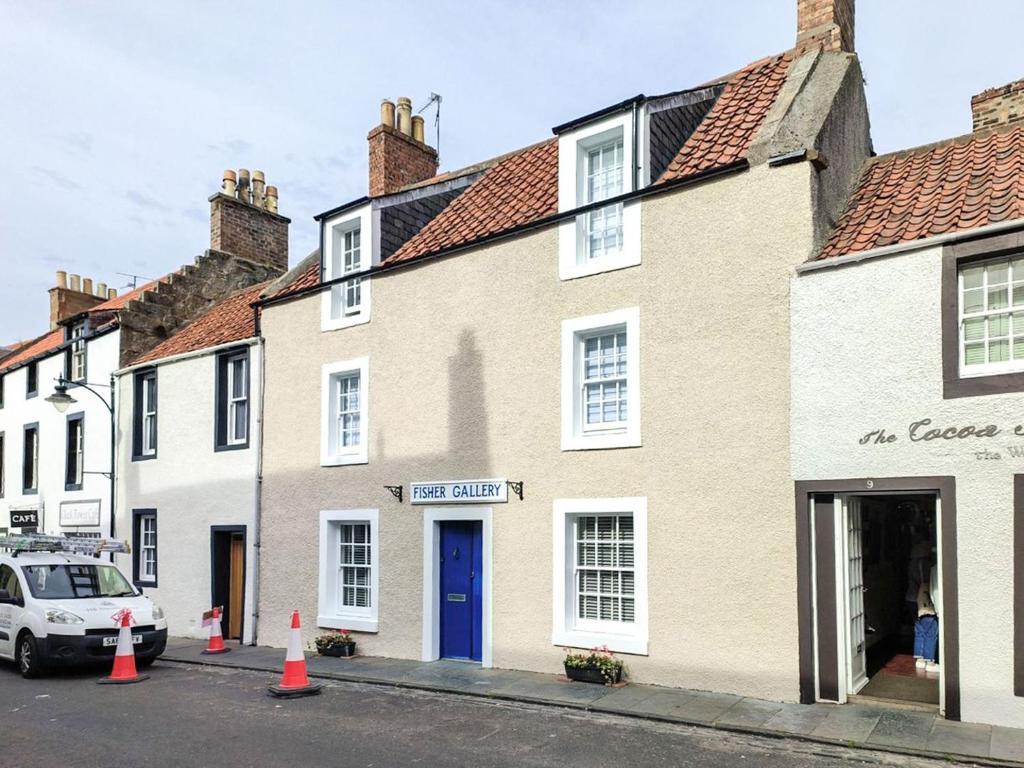 a row of houses with a car parked in front at Fisher Gallery in Pittenweem