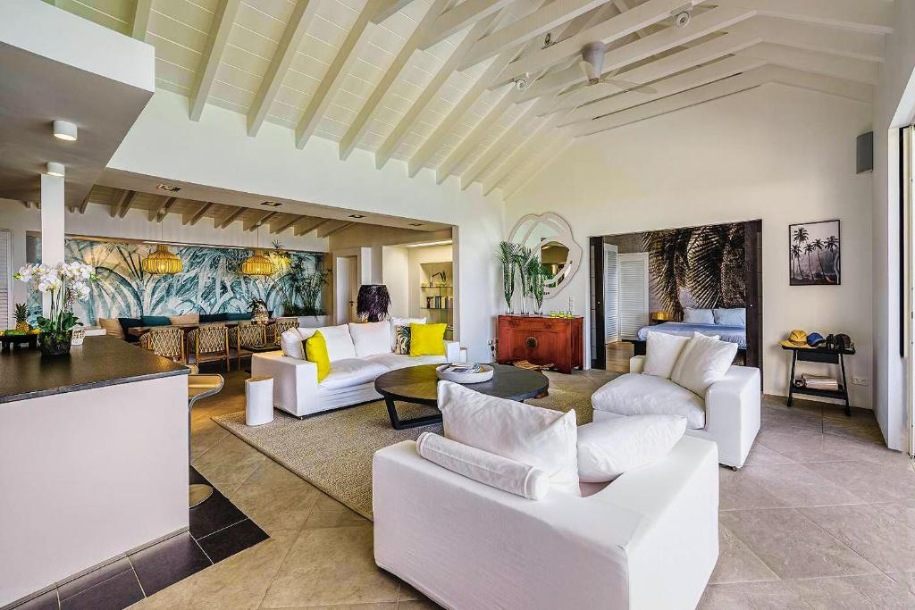 a living room with white couches and a table at Infiniti Entire Luxury Villa Breath Taking View in St Barth in Pointe Milou