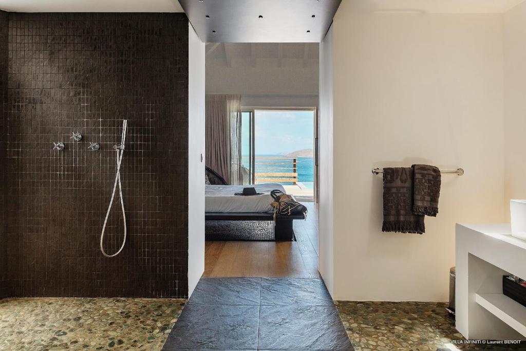 a bathroom with a shower and a bedroom with a bed at Infiniti Entire Luxury Villa Breath Taking View in St Barth in Pointe Milou