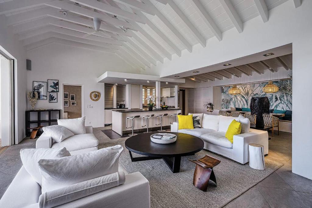 a living room with white couches and a table at Infiniti Entire Luxury Villa Breath Taking View in St Barth in Pointe Milou