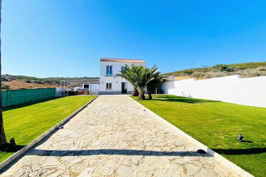 una entrada que conduce a una casa blanca con un patio de césped en Villa La Roca en Torreguadiaro