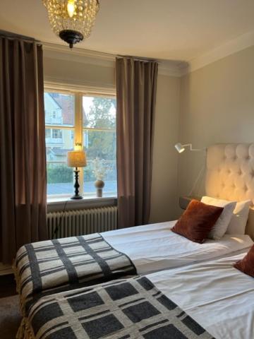 a bedroom with a large bed and a window at Hotell Östermalm in Motala