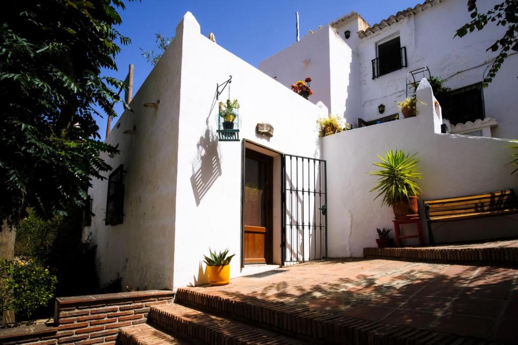 una casa bianca con scale che la conducono di The Studio Under The Wall, a colourful, small and unique one bedroom studio in Comares a Comares