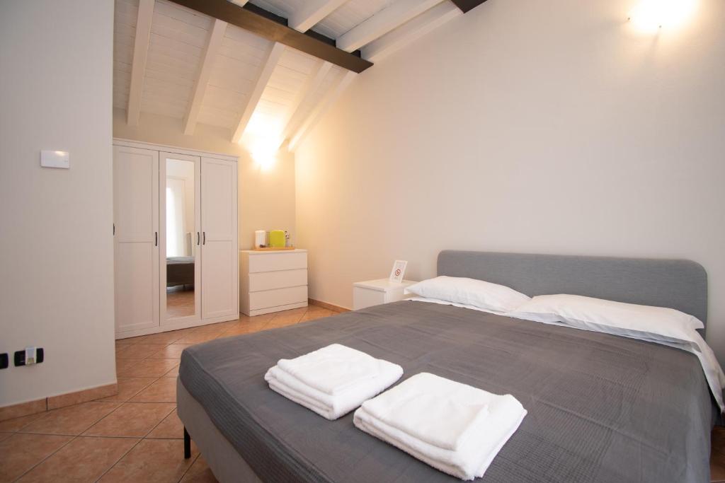 ein Schlafzimmer mit einem Bett mit drei Handtüchern darauf in der Unterkunft Corte Poliambulanza - F&L Apartment in Brescia